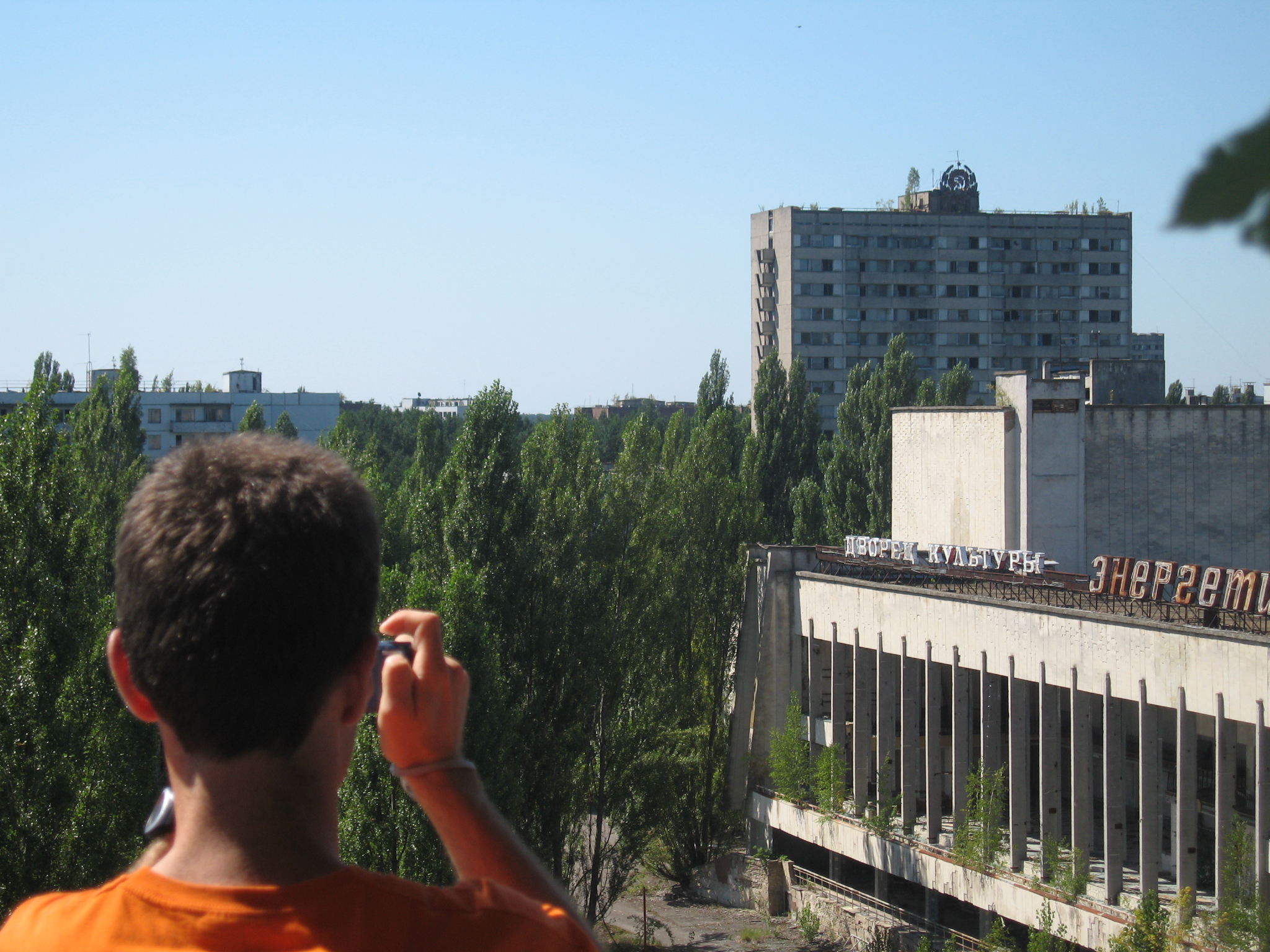 A tourist overlooking the overgrown city of Pripyat inside the Exclusion Zone